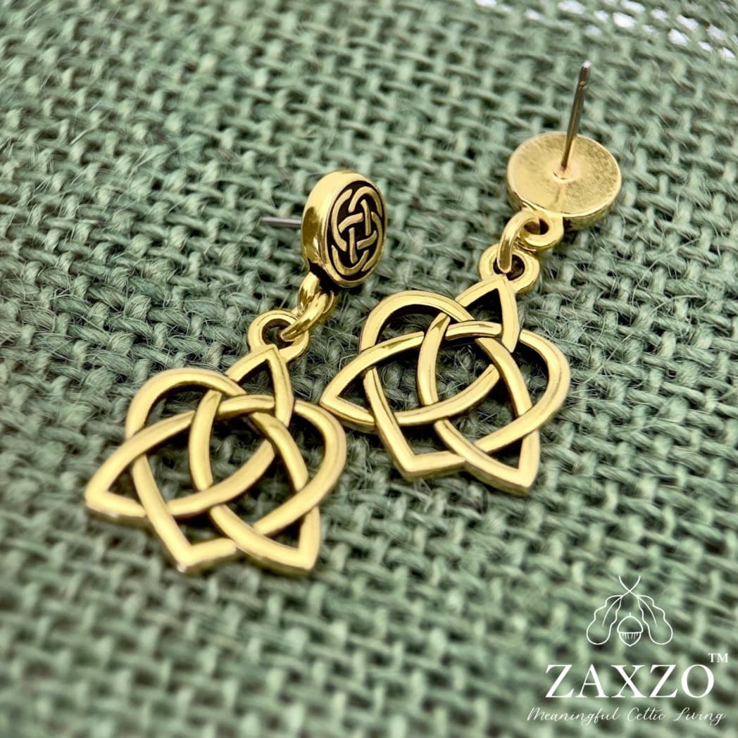 Gold Celtic sister knot earrings with hypoallergenic platinum ear post on green background.