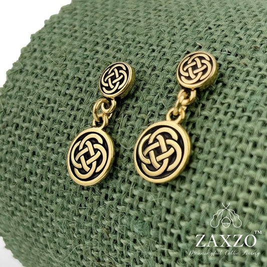 Small gold Celtic Dara knot earrings with hypoallergenic platinum ear post on green background.