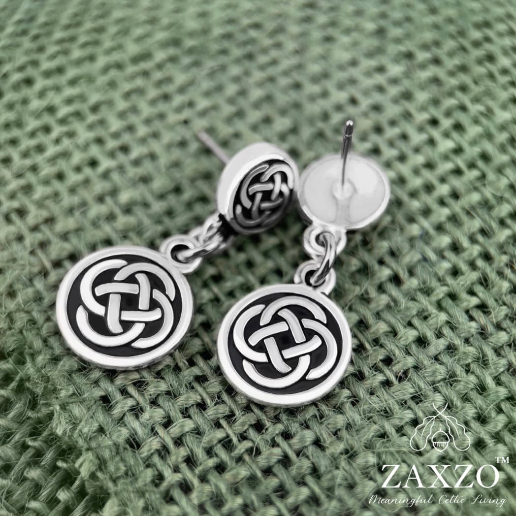 Small silver Celtic Dara knot earrings with hypoallergenic platinum ear post on green background.