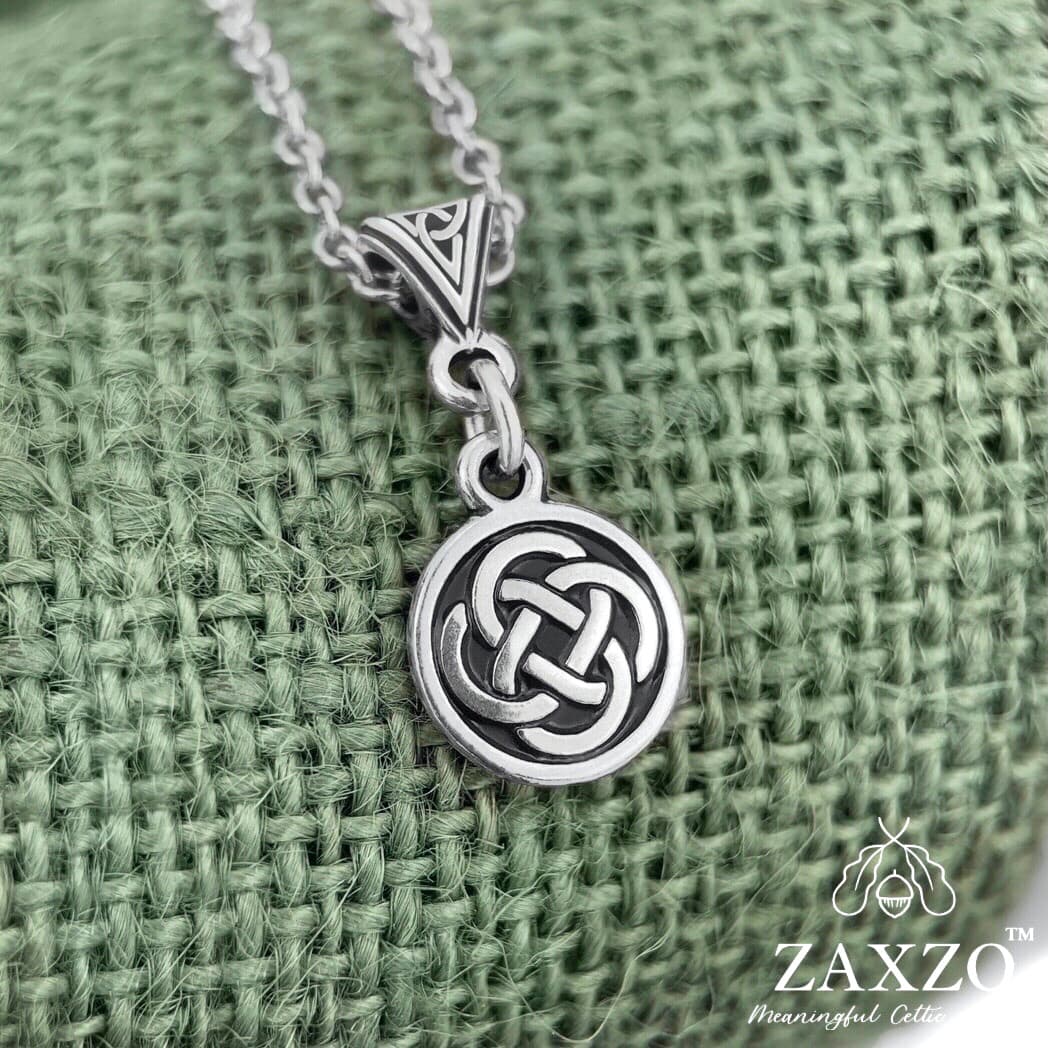Small gold celtic Dara knot necklace on trinity bail on green background 