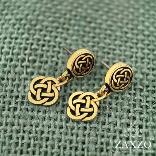 Tiny gold Celtic Dara knot earrings with hypoallergenic platinum ear post on green background.