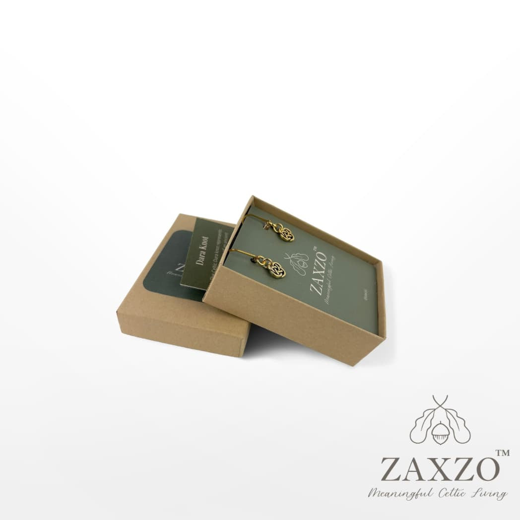 Tiny gold Dara knot platinum post earrings in open gift box with card explaining the meaning.