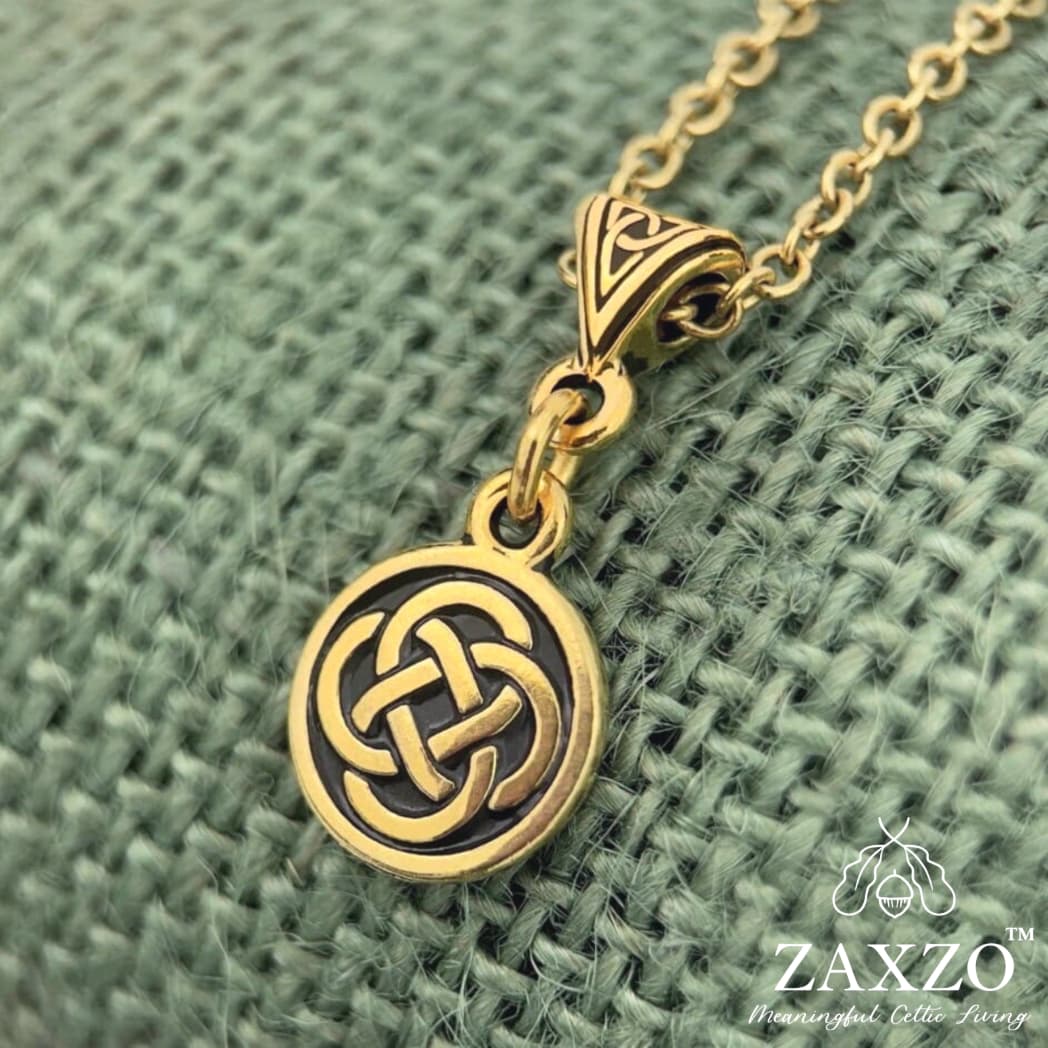 22 karat gold plate small Dara knot with trinity bail on chain between a ruler and quarter.