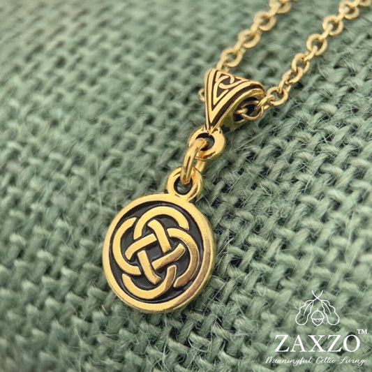 22 karat gold plate small Dara knot with trinity bail on chain between a ruler and quarter.