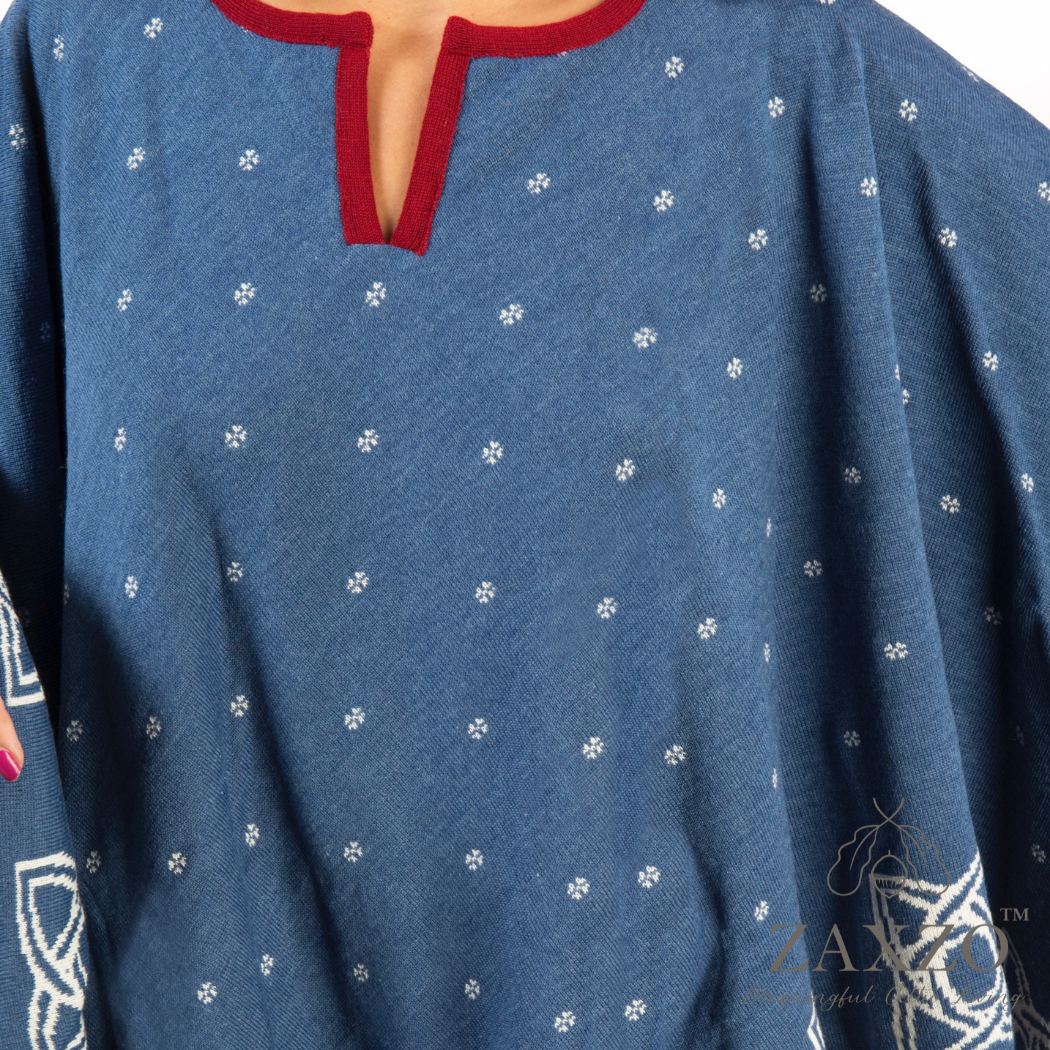 Closeup of America poncho in denim blue with winter white contrast pattern and red trim shown from front