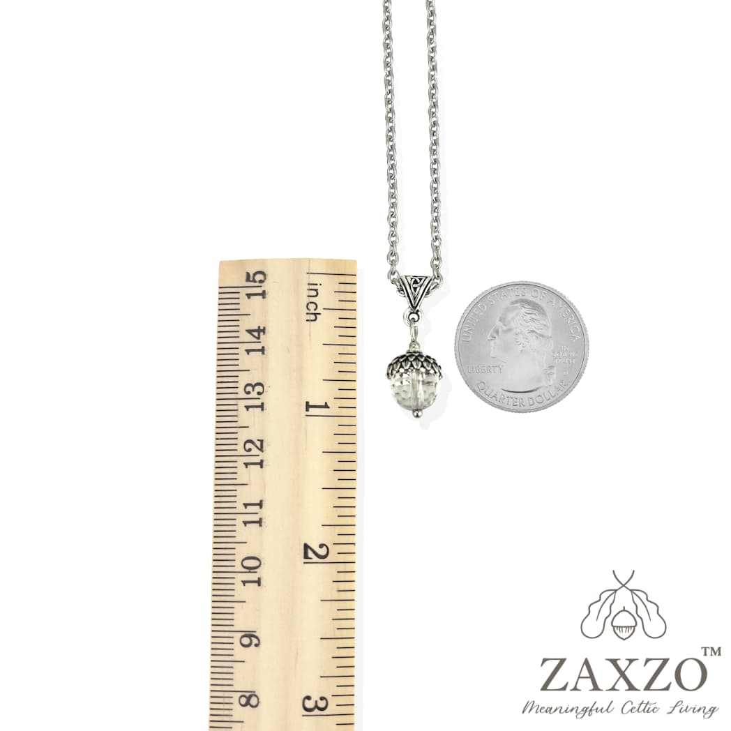 Celtic necklace with silver acorn cap over clear crystal quartz bead between ruler and quarter