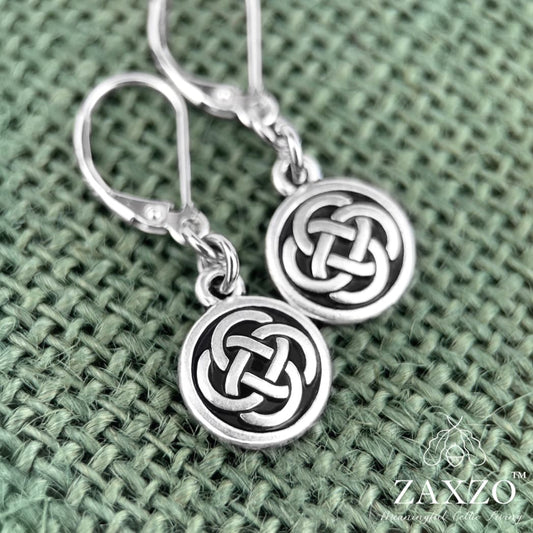 Small Celtic silver Dara knot earrings with lever back ear wire on green background.